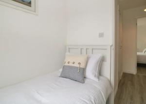 a white bed with a pillow on top of it at Sandown - 2 minutes walk to the Downs, Restaurants Bars & Beaches in Torquay