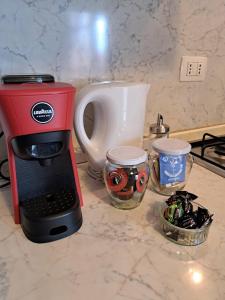 - une cafetière rouge assise sur un comptoir à côté d'une cuisinière dans l'établissement Casa Barbara, à Corsico