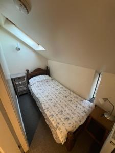 a small bedroom with a bed and a window at Willow cottage with private hot tub in Upper Hulme