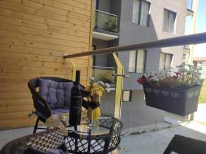 a glass table with a bottle of wine on a balcony at Crystal Wood Apartment 213 in Bakuriani