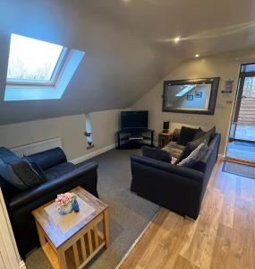 a living room with two couches and a tv at Willow cottage with private hot tub in Upper Hulme
