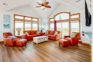 a living room with orange furniture and windows at Blue Waters #18-22 in Avon