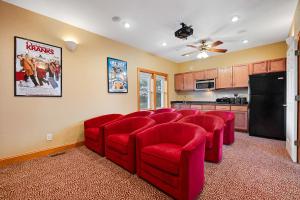 a living room with red chairs and a kitchen at Blue Waters #18-22 in Avon