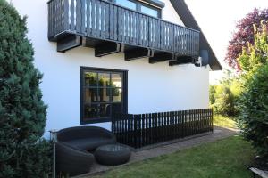 a house with a balcony and a couch in the yard at Ferienwohnung Lohrenz in Goslar