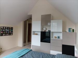 Schlafzimmer mit weißen Wänden und einem Bett in der Unterkunft B&B avec piscine proche de Paris in Maisons-Laffitte