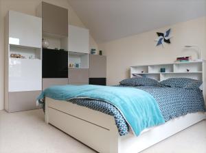 ein weißes Schlafzimmer mit einem Bett mit blauer Decke in der Unterkunft B&B avec piscine proche de Paris in Maisons-Laffitte