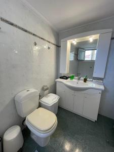 een witte badkamer met een toilet en een wastafel bij Antonello House in Lixouri