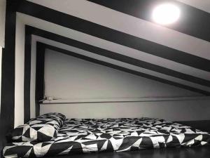 1 dormitorio con una pared a rayas en blanco y negro en D’HIDE OUT (place to have fun) en Cabanatuan