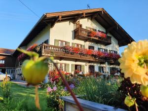 ein Gebäude mit Blumen auf der Seite in der Unterkunft Schneiderhof Ferienwohnung mit Alpenblick in Fischbachau