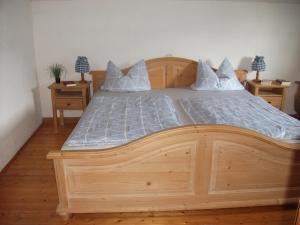 ein Holzbett in einem Schlafzimmer mit zwei Nachttischen in der Unterkunft Schneiderhof Ferienwohnung mit Alpenblick in Fischbachau