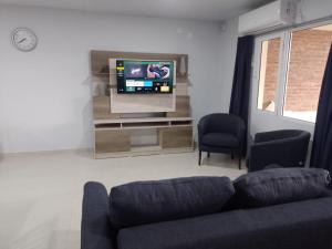 salon z kanapą i telewizorem z płaskim ekranem w obiekcie CASA QUINTA CON PILETA, GALERIA, IMPECABLE , AIRE, WIFI w mieście Santa Rosa