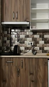 a kitchen with wooden cabinets and a brick wall at İstiklal hostel istanbul in Istanbul