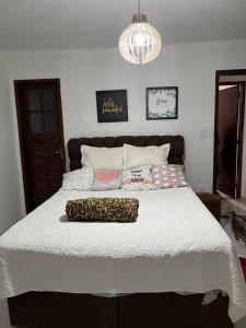 a bedroom with a large bed with a white comforter at Casa em Praia Seca, Araruama. in Araruama