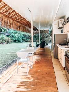 a kitchen with a table and chairs on a wooden floor at Vaikea Fare in Mahina