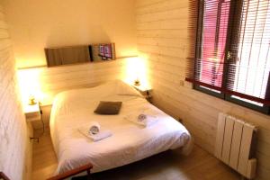 a bedroom with a bed with two towels on it at Pretty house with double terrace near the ocean in Moliets-et-Maa