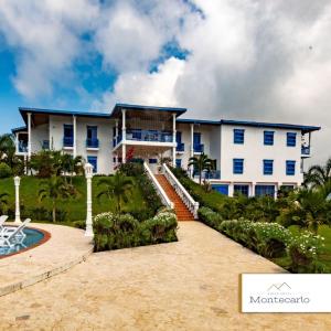 a large white building with blue windows at Finca Hotel Monte Carlos in Santa Bárbara
