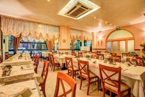 um restaurante com mesas e cadeiras e uma grande janela em Casa Stella Marina em Bellaria-Igea Marina