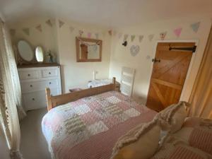um quarto com uma cama e uma porta de madeira em Maytree Cottage. Compact home in Mid Wales. em Llanrhaeadr-ym-Mochnant
