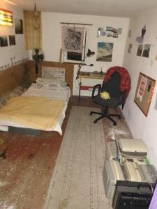 a room with a bed and a chair and a desk at Ruhig und spartanisch Wohnen im Denkmal in Lichtenwalde