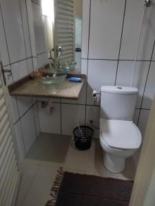 um banheiro com vaso sanitário e pia em Chácara talismã 3 em Olímpia