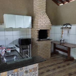 uma cozinha com fogão e um forno de tijolos em Chácara talismã 3 em Olímpia
