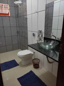 um banheiro com pia e vaso sanitário em Chácara talismã 3 em Olímpia mais 3 fotografias