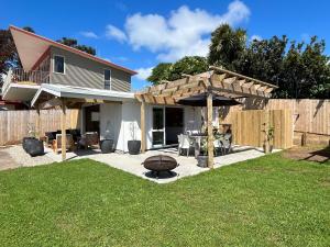 a backyard with a table and a wooden fence at The Raglan Harbourside Hutch in Raglan