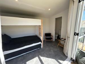 a bedroom with a bed and a large window at The Raglan Harbourside Hutch in Raglan