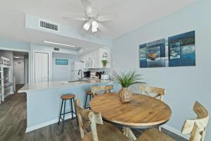 cocina y comedor con mesa de madera y sillas en Seacrest 507, en Gulf Shores
