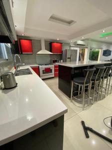 a kitchen with white counter tops and red cabinets at Rest House in Rafael Castillo