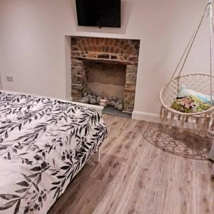 un salon avec un lit et une cheminée dans l'établissement Luxury 300yr old Irish thatch cottage close to sea, à Rush