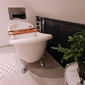 une salle de bain avec une baignoire blanche et un lavabo dans l'établissement Luxury 300yr old Irish thatch cottage close to sea, à Rush 22 autres photos