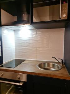 un comptoir de cuisine avec un évier et un micro-ondes dans l'établissement Luxury 300yr old Irish thatch cottage close to sea, à Rush