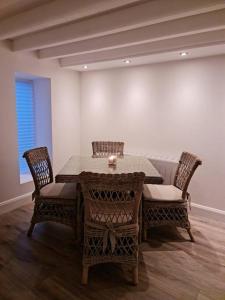 une salle à manger avec une table et quatre chaises dans l'établissement Luxury 300yr old Irish thatch cottage close to sea, à Rush