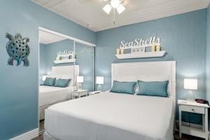 1 dormitorio con 2 camas y pared azul en Seashells Getaway, en Marathon