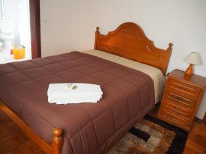 Un dormitorio con una cama marrón con una toalla. en Monte Carlo - Alojamento Local, en Pedras Salgadas