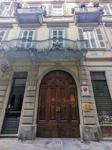 a building with a large wooden door and a balcony at Atelier Relax Petit Turin - Centralissimo in Turin