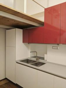 a kitchen with a sink and red cabinets at Atelier Relax Petit Turin - Centralissimo in Turin