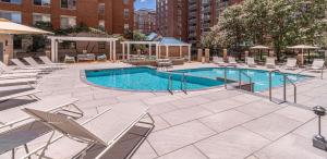 a pool with chaise lounge chairs and a swimming pool at Quiet Condo in the Heart of Ballston in Arlington