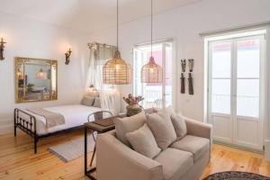 een woonkamer met een bank en een bed bij 157 Flores Apartment in Porto