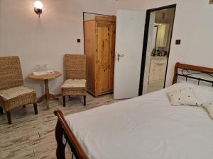 a bedroom with a bed and two chairs and a table at Agroturystyka Gramburg in Zblewo