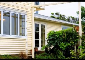 ein Haus mit einem großen Fenster an der Seite in der Unterkunft Cottage House in Wellington