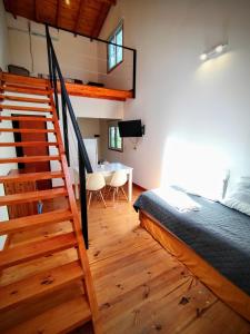 a bedroom with a bed and a staircase and a table at Cedro Azul in La Cumbre
