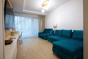 a living room with a blue couch and a television at Premier Luxury Apartment Lake On in Mamaia