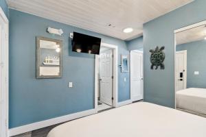 a blue bedroom with a bed and a flat screen tv at Seashells Getaway in Marathon
