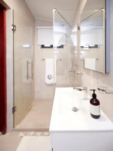 a white bathroom with a shower and a sink at Stylish 2 Bedroom in Osu in Accra