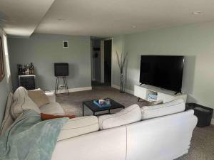 ein Wohnzimmer mit einem weißen Sofa und einem Flachbild-TV in der Unterkunft Luxury Home Fenced In Yard Palos Heights 3BR/2BA 