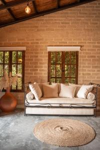 ein Sofa in einem Zimmer mit Ziegelwand in der Unterkunft Privada y comoda cabaña, Casa Margarita, Villavieja in Villavieja