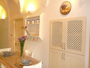 a kitchen with a table and a clock on the wall at Casa Della Lavanda in Santo Stefano al Mare