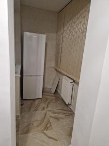 a kitchen with a white refrigerator in a room at The Nest in Brăila